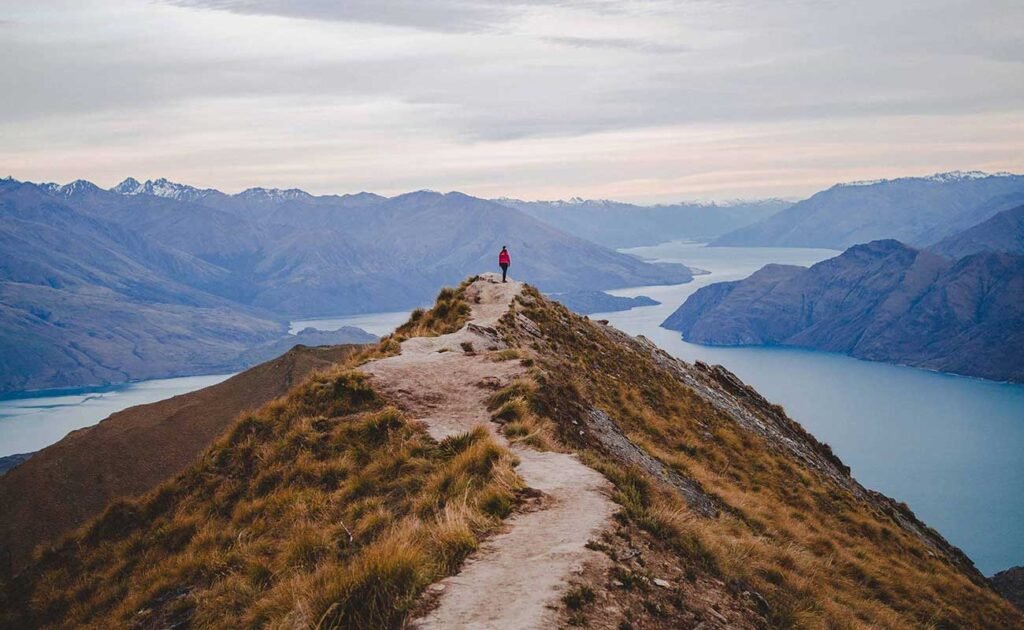 vertical high angle shot person standing end walking road roys peak new zealand